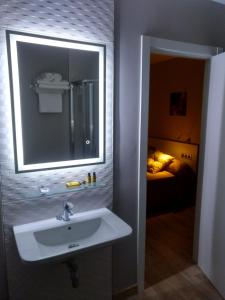 a bathroom with a sink and a mirror and a bed at Travesia Rooms in Sarria +55 photos