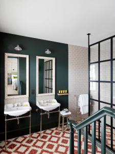 a bathroom with two sinks and two mirrors at No131 The Promenade in Cheltenham