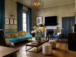 a living room with a blue couch and a tv at No131 The Promenade in Cheltenham