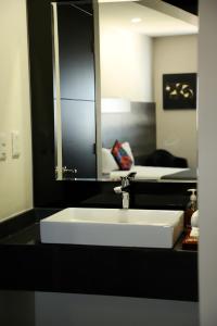 a bathroom with a white sink and a mirror at Homesuites Malecon in Culiacán