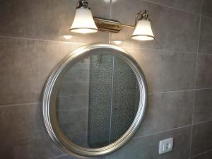 a bathroom mirror with two lights on a wall at Bossa Studio Apartments in Split