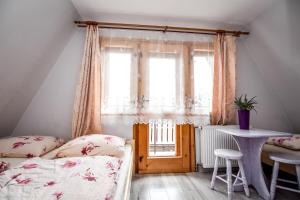 a bedroom with a bed and a table and a window at Dom Wypoczynkowy u Ewy in Biały Dunajec