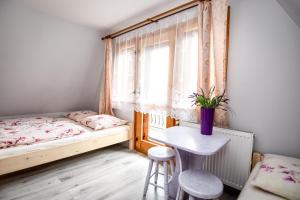 sypialnia z 2 łóżkami, stołem i oknem w obiekcie Dom Wypoczynkowy u Ewy w Białym Dunajcu