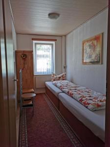 um pequeno quarto com uma cama e uma janela em Ferienwohnungen Ludolph em Erfurt