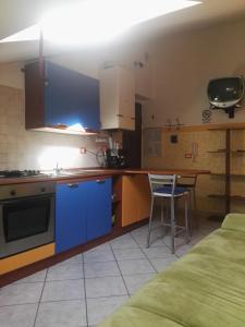 een keuken met blauwe kasten en een tafel en stoelen bij Le mansarde di Via Isonzo in Chieti