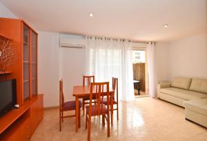 a living room with a table and chairs and a couch at Apartment Didier in Lloret de Mar