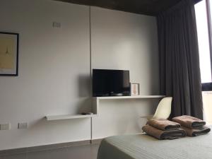 ベレン・デ・エスコバルにあるHipolito Estudio Iの壁にテレビが付いたベッドのある寝室
