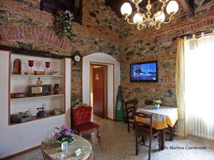 a dining room with a table and a tv on a brick wall at Bed & Breakfast Garrupa in Marcellinara