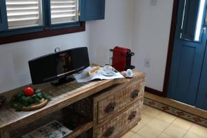 a table with a television on top of a dresser at Chalé Clássico in Lavras Novas +33 photos