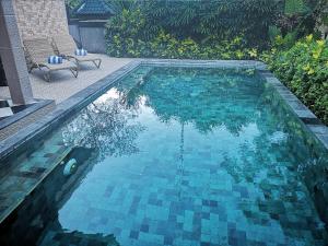 a swimming pool with a ball in the water at Villa with private pool at Villa Nirvana Ubud in Ubud
