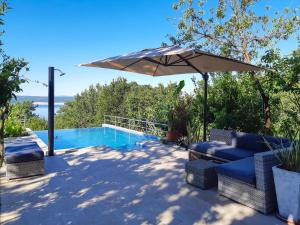 a patio with an umbrella and a swimming pool at Apartment Milka in Dramalj
