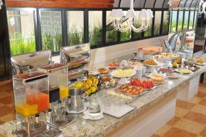 uma linha de buffet com muitos tipos diferentes de alimentos em Cosmos Hotel em Caxias do Sul