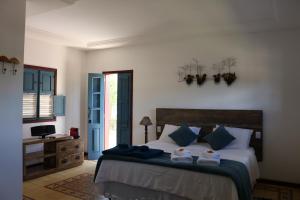 1 dormitorio con 1 cama con 2 toallas en Chalé Clássico, en Lavras Novas