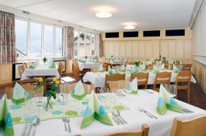 a room with tables and chairs with white tablecloths at Hotel Krone in Attinghausen