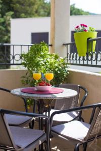 una mesa con 2 copas de vino en el balcón en Villa Sandra en Petrovac na Moru