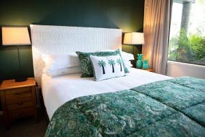 a bedroom with a large bed with a green wall at Emerald Inn on Takapuna Beach in Auckland