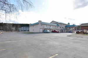 a parking lot in front of a large building at Ramada Limited 100 Mile House in One Hundred Mile House