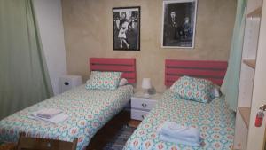 ヘレス・デ・ラ・フロンテーラにあるVilla Marinaのベッドルーム1室(ベッド2台付)が備わります。壁に2枚の写真が飾られています。