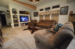 a living room with couches and a flat screen tv at The Bear's Den B&B in Page