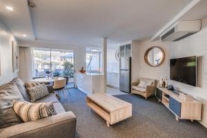 a living room with a couch and a table at Hotel Laguna in Noosa Heads