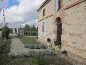 a brick building with some plants in front of it at L'OUSTAL D'ADELE proche Canal du Midi et Moissac in Saint-Nicolas-de-la-Grave