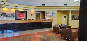 a lobby with a waiting area with chairs and a bar at Red Carpet Inn-Macon in Macon
