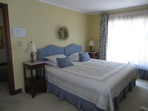 a bedroom with a blue bed and a window at Cedar Gables Bed & Breakfast in Niagara-on-the-Lake