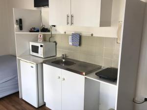 una pequeña cocina con fregadero y microondas en Lake Albert Caravan Park en Meningie