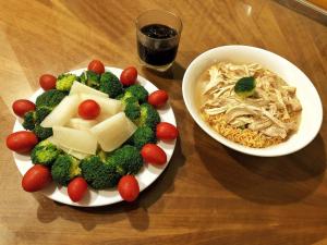 two plates of food with broccoli and a bowl of noodles at CornerCatBa in Cat Ba