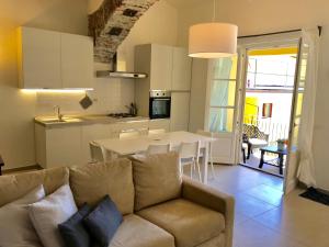 ein Wohnzimmer und eine Küche mit einem Sofa und einem Tisch in der Unterkunft appartamento Cortile in Cannobio
