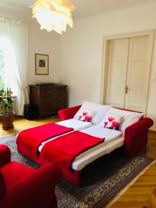 フェルデン・アム・ヴェルターゼーにあるVilla Adrienneのベッドルーム1室(赤毛布付きの大型ベッド1台付)