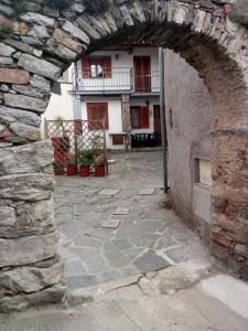 uma entrada para um edifício de pedra com uma parede de pedra em Il Castello em Nebbiuno