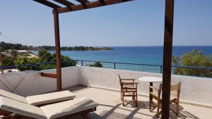 een balkon met een tafel en stoelen en de oceaan bij Andreas Studios in Pefki Rhodes