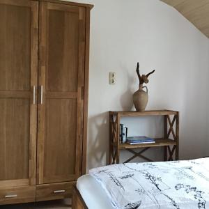 a bedroom with a bed and a wooden cabinet at Meyers Ausguck in Zingst
