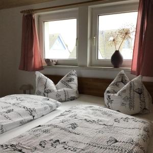 a bedroom with two beds with pillows and a window at Meyers Ausguck in Zingst