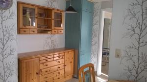a kitchen with a wooden dresser and a blue wall at Ferienwohnung Ahoi in Putbus
