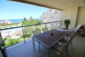 een balkon met een tafel en stoelen en uitzicht op de oceaan bij Tierra de mar 67 in Denia