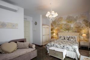 ニコロージにあるB&B Blanc Maison Etna Relais & Charmeのベッドとソファのある寝室