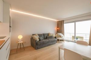 a living room with a couch and a table at Studio Zeezicht fully renovated in Ostend