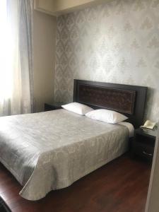 エッセントゥキにあるGuest House Luxorのベッドルーム1室(白い掛け布団付きのベッド1台付)