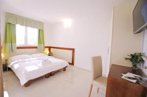 ein Schlafzimmer mit einem Bett, einem Schreibtisch und einem Fernseher in der Unterkunft Apartman Murter Center 4+1 ID 720 in Murter