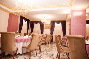 une salle à manger avec des tables et des chaises ainsi qu'un lustre dans l'établissement Royal Boutique Mangalia Breeze, à Mangalia