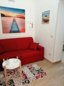 a living room with a red couch and a table at Casa per Vacanze a Marsala in Marsala