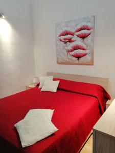a red bed in a room with a painting on the wall at Casa per Vacanze a Marsala in Marsala