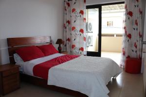 Schlafzimmer mit einem Bett mit roten Kissen und Vorhängen in der Unterkunft Mahina Luxury 2 Bedroom Apartment with Pool in Flic-en-Flac