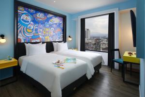 a hotel room with a large bed and a window at de Braga, ARTOTEL Curated in Bandung