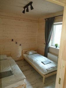 1 Schlafzimmer mit 2 Betten und einem Fenster in der Unterkunft Mizarai Mill House in Druskininkai