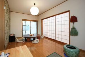 ein Wohnzimmer mit einem Tisch und einem großen Fenster in der Unterkunft Ryokan ASAKUSA-chaka- in Tokio