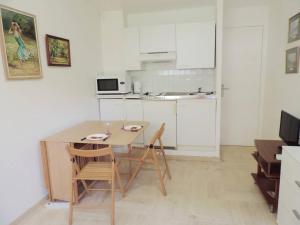 a kitchen with a table and chairs in a room at #PACAGROOM# Studio Alexandre III in Cannes