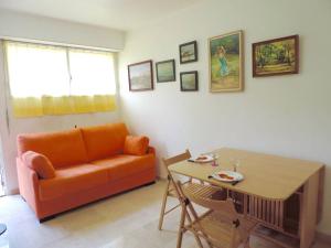 sala de estar con sofá naranja y mesa en #PACAGROOM# Studio Alexandre III en Cannes